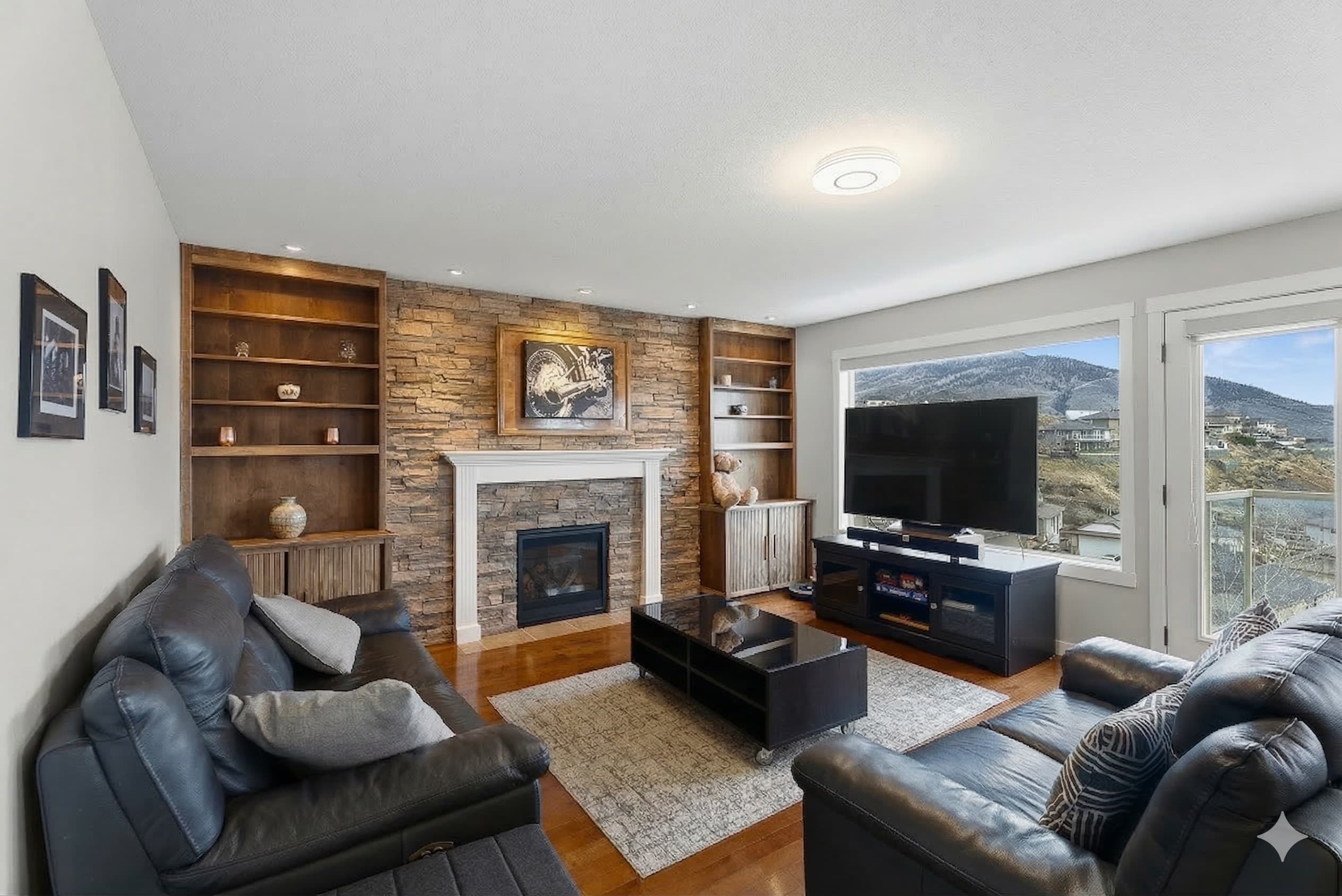Stone fireplace with built-ins, hardwood floors, valley views